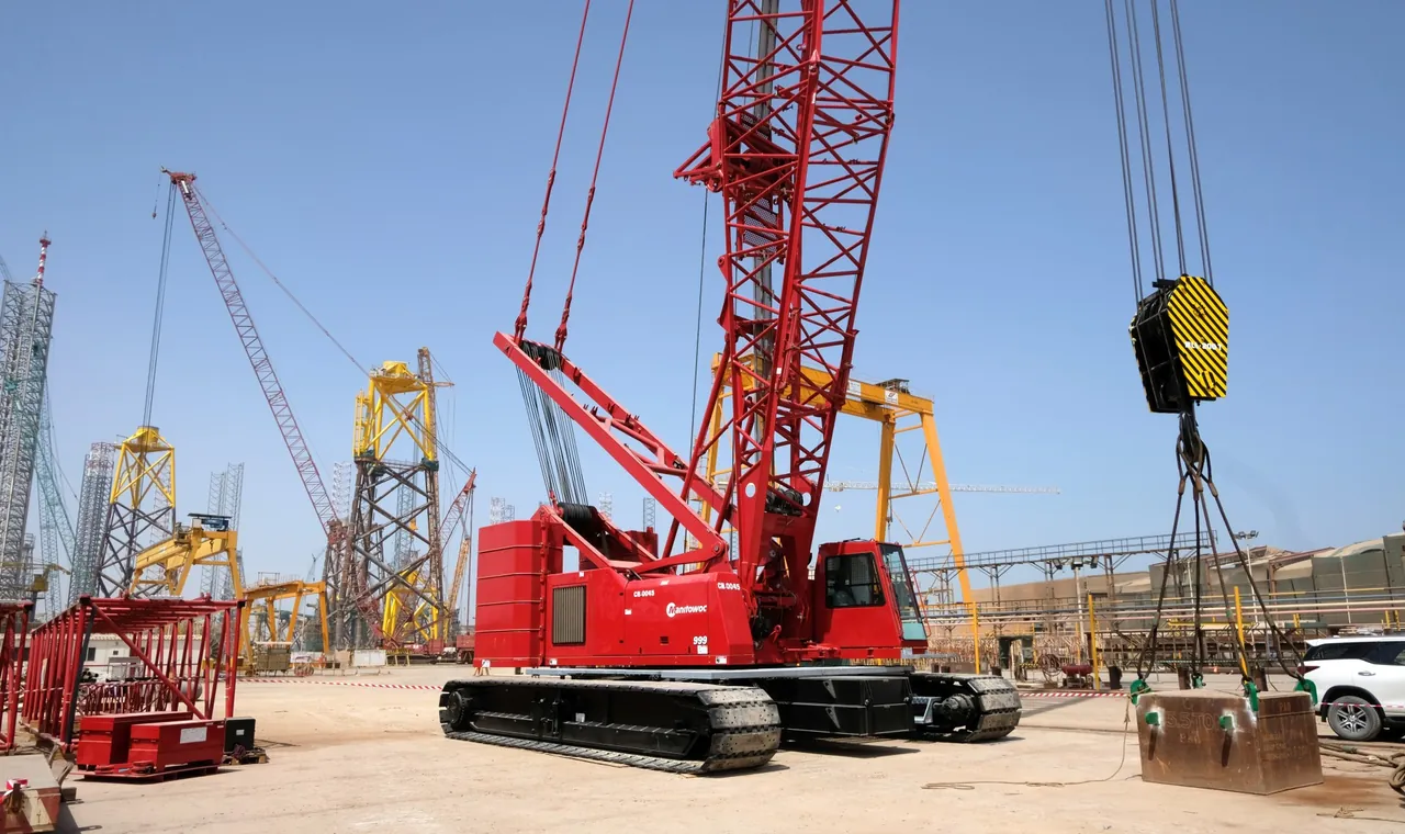 Manitowoc 999 lattice-boom crawler crane at a fabrication yard