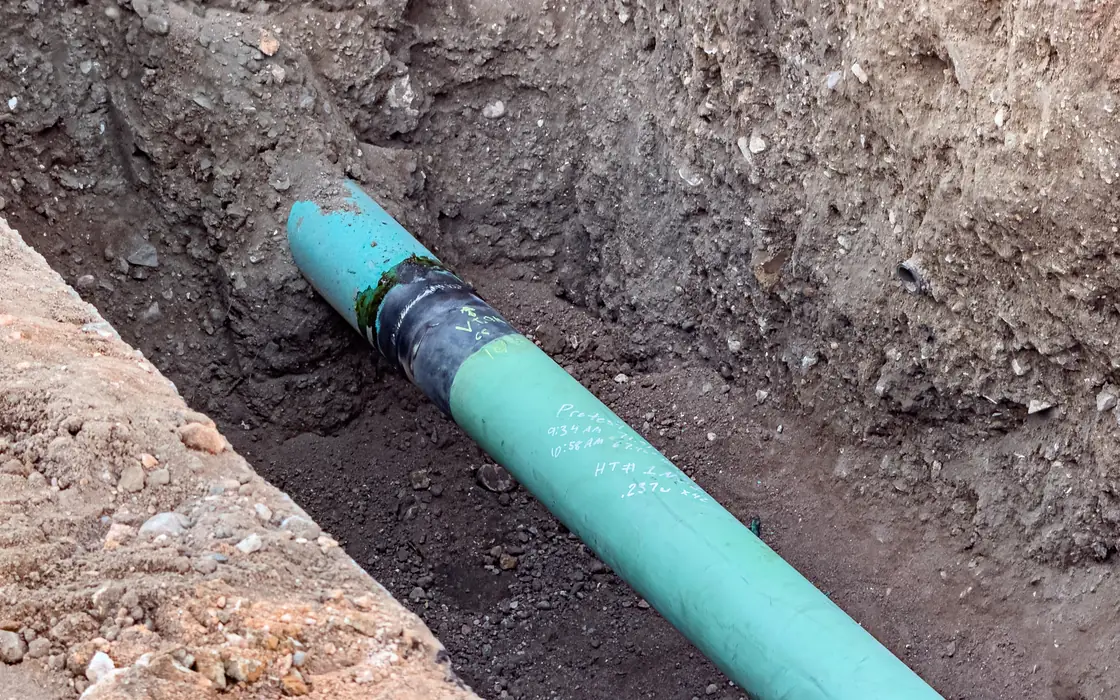 Repaired section of a buried steel gas line in an open trench
